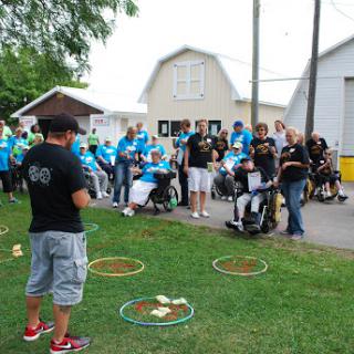 A community event featuring activities for individuals, including those in wheelchairs, gathered outdoors.