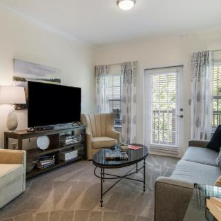 A cozy living room featuring modern furniture and a large TV.