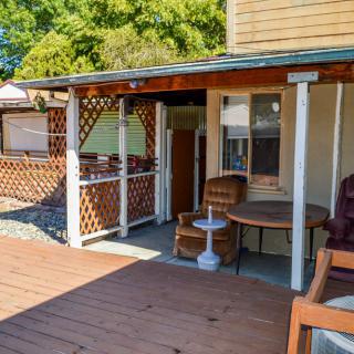 A sunny outdoor patio with wooden decking and comfortable seating.