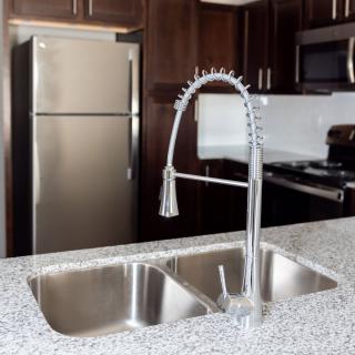 Modern kitchen with stainless steel appliances and granite countertops.