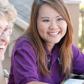 Two people smiling and enjoying a conversation outdoors.