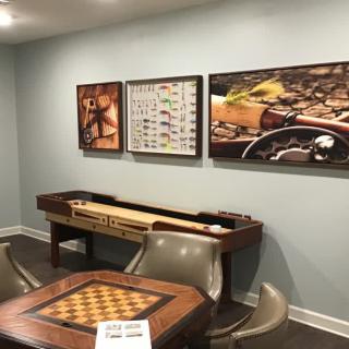 A cozy game room featuring a shuffleboard table, chess table, and wall art.