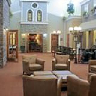 A cozy seating area in a building lobby with armchairs and decorative lighting.