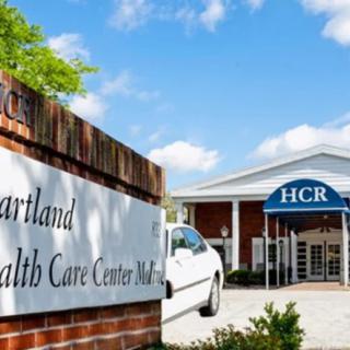 Entrance to a healthcare center with signage and parking.