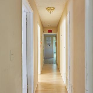 A well-lit hallway with doors leading to different rooms.