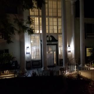 A well-lit entrance of a grand building captured at night.