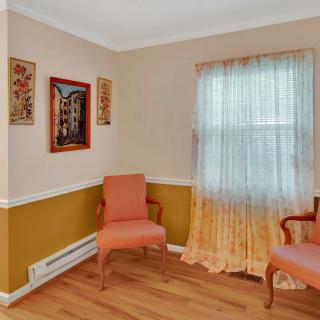 A cozy corner of a living room with two upholstered chairs and decorative wall art.