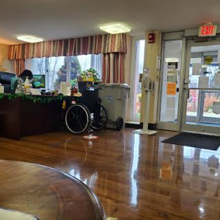 A cozy lobby with a reception desk and a wheelchair, designed for accessibility.
