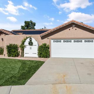 A suburban house with a two-car garage and solar panels on the roof.