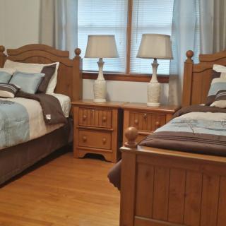 A cozy bedroom with twin wooden beds and matching bedside lamps.