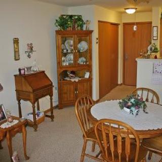 A cozy dining area with a wooden table, chairs, and a china cabinet.