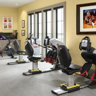 A well-equipped gym featuring several stationary bikes in a bright and spacious indoor setting.