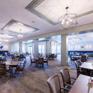 Spacious restaurant dining area with modern lighting and neatly arranged tables.