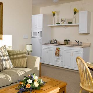 A cozy living area with a small kitchenette, sofa, and dining table.