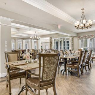 An elegantly decorated dining area with chandeliers and well-arranged tables and chairs.