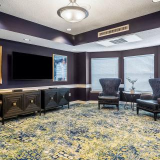 A stylish living room with modern furniture, featuring a television and artistic decor.