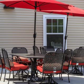 An outdoor patio with red umbrellas and a dining set.