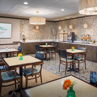 A cozy dining area with modern decor and floral arrangements on the tables.