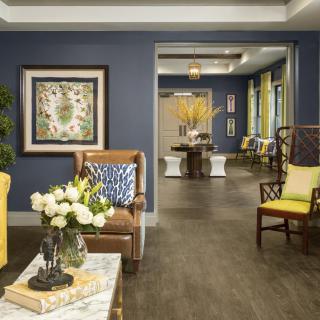 A cozy living room with blue walls, decorated with elegant furniture and floral accents.