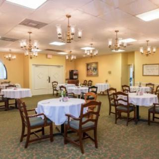 An elegantly set dining room with multiple tables and chandeliers.