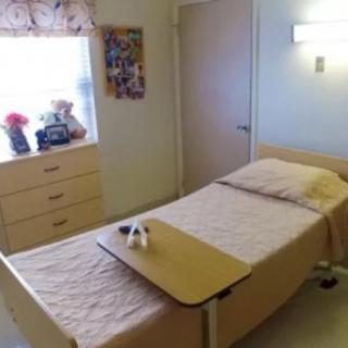 A hospital room with a single bed and medical equipment.