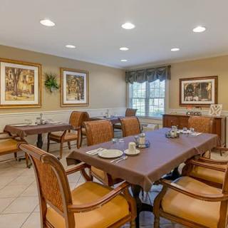 A well-appointed dining room with tables and chairs, complemented by artwork and natural lighting.