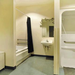 A modern bathroom with a bathtub, sink, and shower curtain.