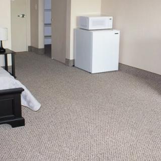 A hotel room featuring a bed, mini refrigerator, and microwave.