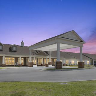 A modern building with a covered entrance at sunset.