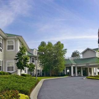 A well-maintained residential building with landscaped surroundings and a driveway.