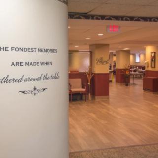 A cozy restaurant interior with a welcoming quote on the wall.