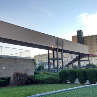 An elevated walkway connecting two buildings in an urban setting.