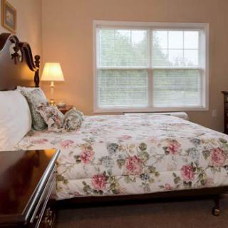 A cozy bedroom with floral bedding and warm lighting.