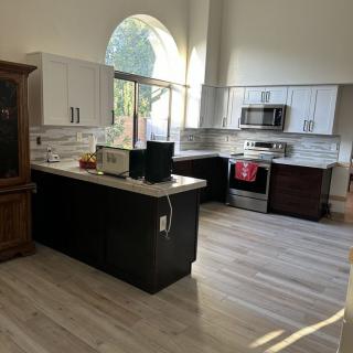 A modern kitchen with sleek appliances and light wood flooring.