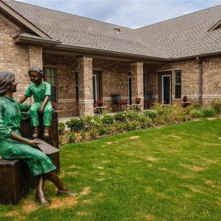 A serene garden with sculptures outside a brick building.