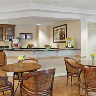 A cozy cafe interior with tables and chairs arranged near a serving counter.