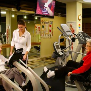 People working out in a gym with exercise equipment.