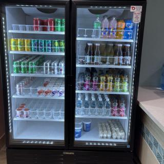 A refrigerator displaying a variety of beverages, including cans and bottles.