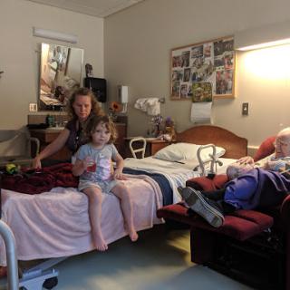 A touching moment in a hospital room where family connects with a patient.