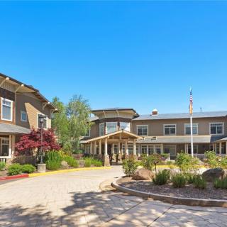 A residential building with landscaped gardens under a clear blue sky.