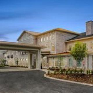 A modern hotel building with a grand entrance and landscaped surroundings.