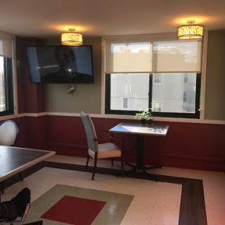 A cozy dining area featuring a small table, a chair, and a television mounted on the wall.