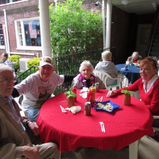 A group of people enjoying a meal together at an outdoor restaurant table.