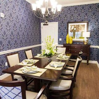 A stylishly decorated dining room with patterned wallpaper and elegant furnishings.