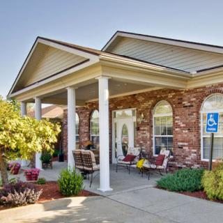 A welcoming building entrance with columns and landscaped surroundings.