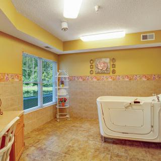 A spacious bathroom featuring a comfortable tub and serene yellow hues.