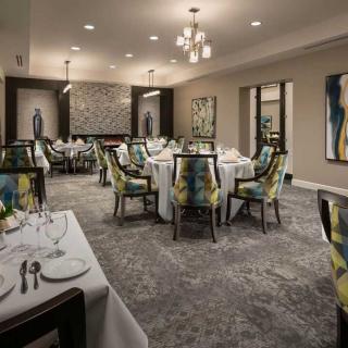 An elegantly set dining room with round tables and stylish decor.