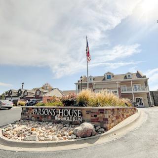 Entrance to a hotel featuring an American flag and landscaped surroundings.