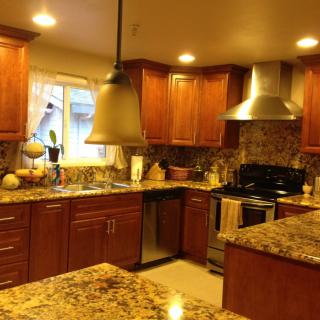 A modern kitchen with wood cabinets and granite countertops.