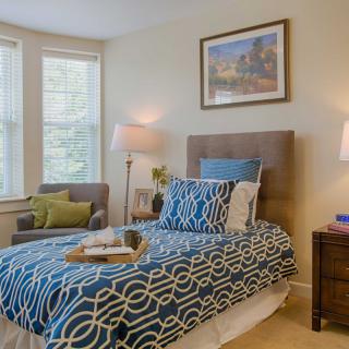 A cozy bedroom with a stylish bed and ample natural light.